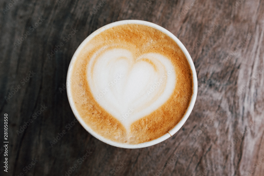 Close up of fresh delicious cappuccino coffee with beautiful latte art in the shape of heart on dark wooden background. Close up of fresh delicious cappuccino coffee with beautiful latte art in the shape of heart on dark wooden background.