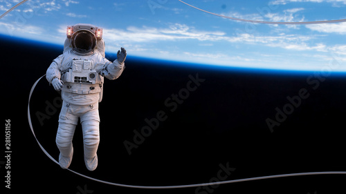 astronaut with safety tether performing a spacewalk in empty space