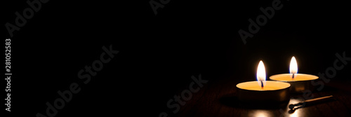 Candles burning in the black background.