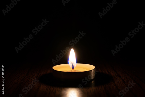 Candle burning in the black background.