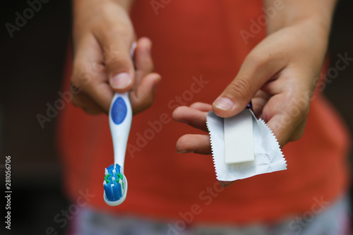 choose between teeth cleaning and chewing gum concept. hands offer to choose between toothbrush and gum