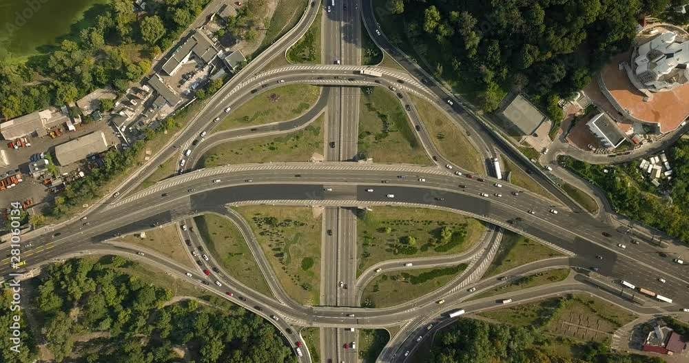 Aerial high drone in 4K flight over evening road traffic in Kiev, Ukraine. Highway and overpass with cars and trucks, interchange, two-level road junction in the big city. Top view. Aerial high drone in 4K flight over evening road traffic in Kiev, Ukraine. Highway and overpass with cars and trucks, interchange, two-level road junction in the big city. Top view.