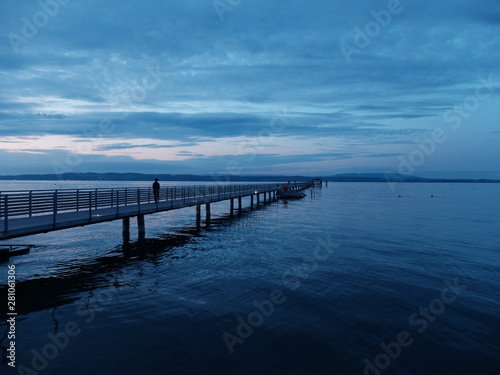 ponton de quai en bois qui rentre dans l'eau le soir  © Ourson+