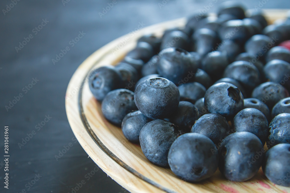 Detail of fresh blueberries on a wooden dish Detail of fresh blueberries on a wooden dish