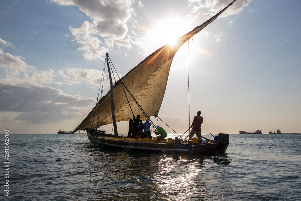 traditional dhow sailing boat with the drew hoisting the mainsail