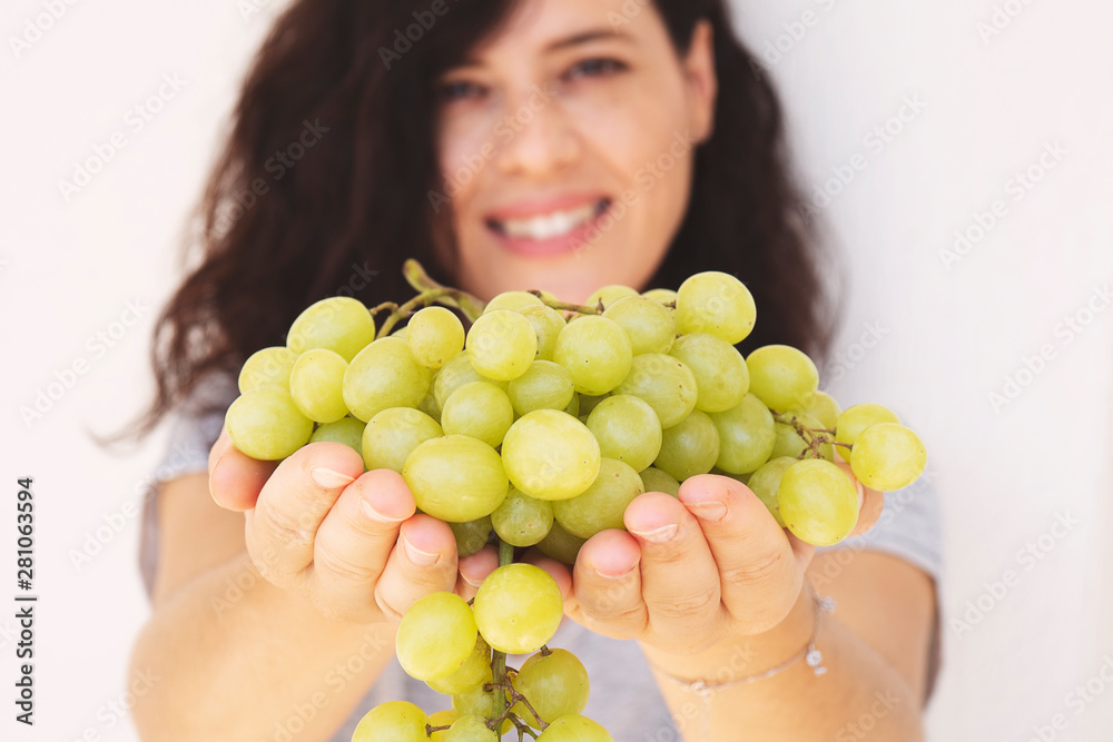 Beautiful woman, holding fresh green grape in handful, isolated on white background. Beautiful woman, holding fresh green grape in handful, isolated on white background.