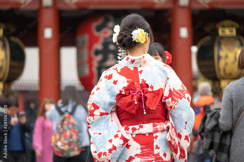 Young girl wearing Japanese kimono standing in front of Sensoji Temple in Tokyo, Japan. Kimono is a Japanese traditional garment. The word 