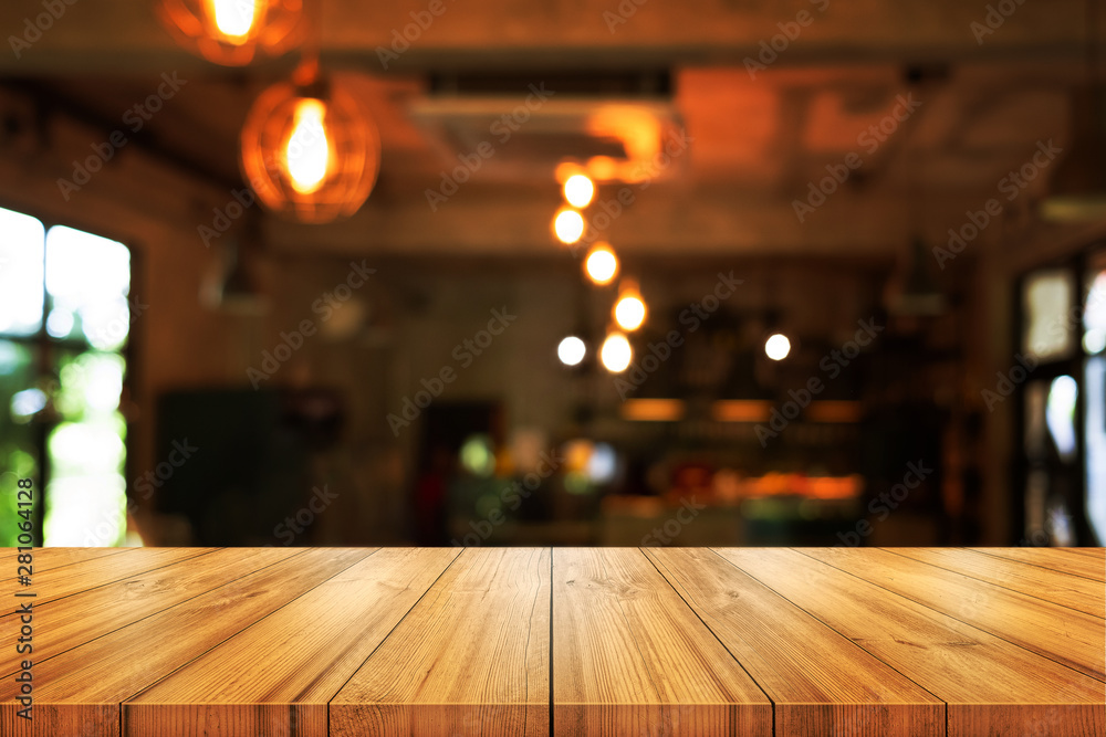 Empty wooden table top with blurred coffee shop or restaurant interior background. can be used product display.