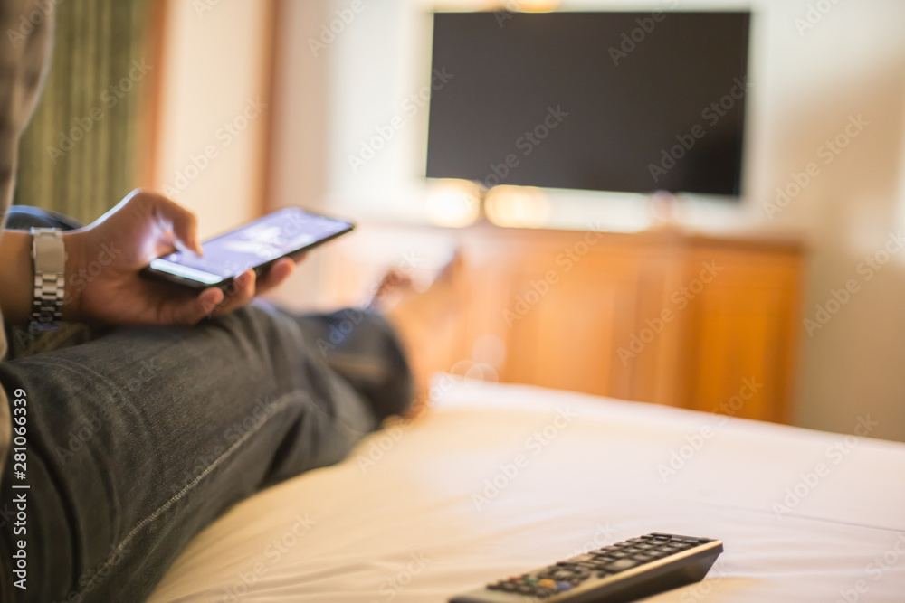 Obraz premium Man using mobile phone in bed room, selective focus and blur background