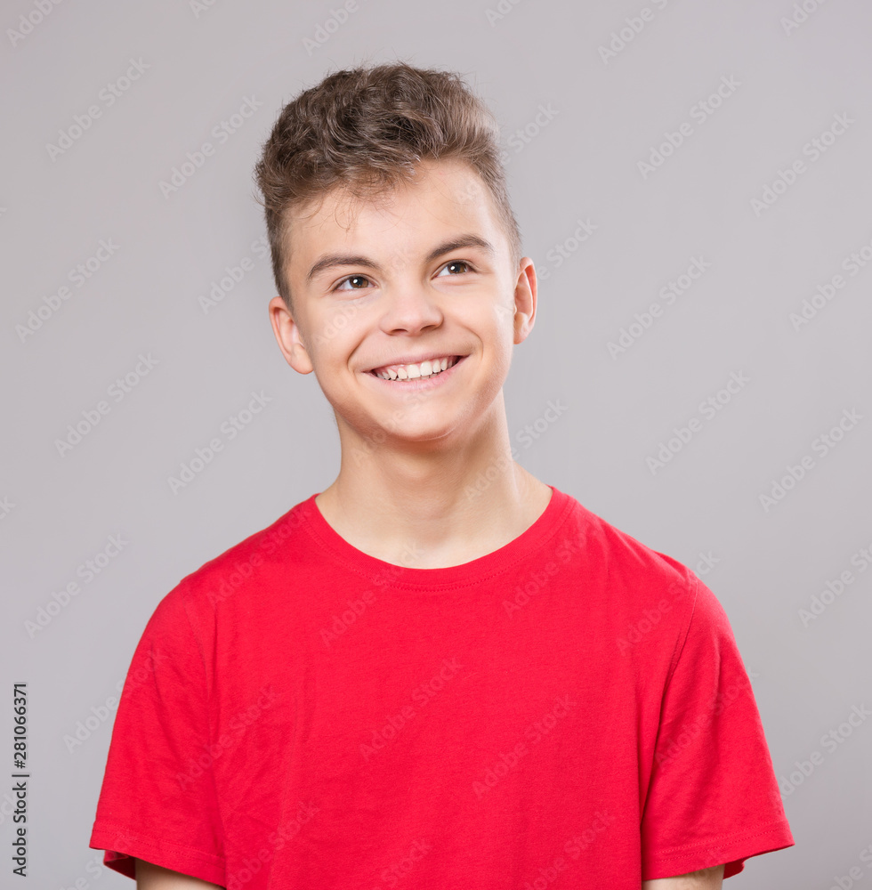 Close up emotional portrait of caucasian teen boy. Handsome smiling guy. Funny cut teenager on gray background. Child looking away. Close up emotional portrait of caucasian teen boy. Handsome smiling guy. Funny cut teenager on gray background. Child looking away.