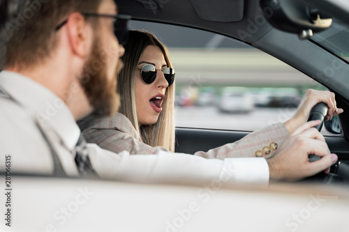 Shocked woman behind the wheel man trying to correct situation 