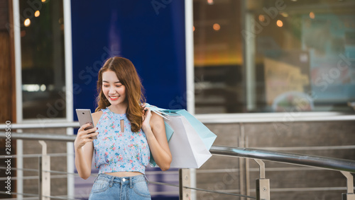 Asia young woman use mobilephone when shopping