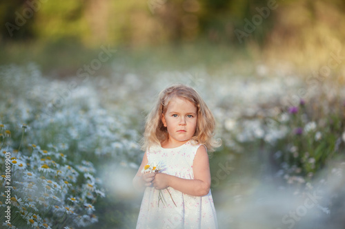 Little cute girl with bouquet of camomile flowers