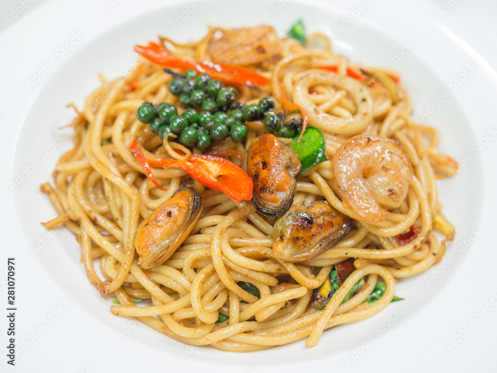 Spaghetti spicy with seafood on a white plate