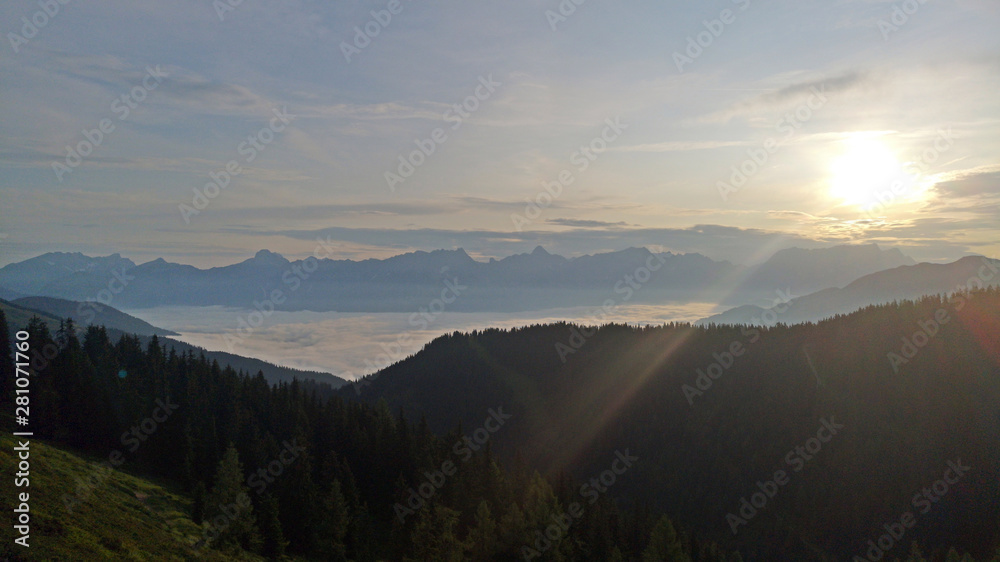 beautiful morning and sunrise in the mountains with view to the alps and fog in the valley