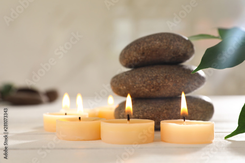 Composition with spa stones and candles on white wooden table