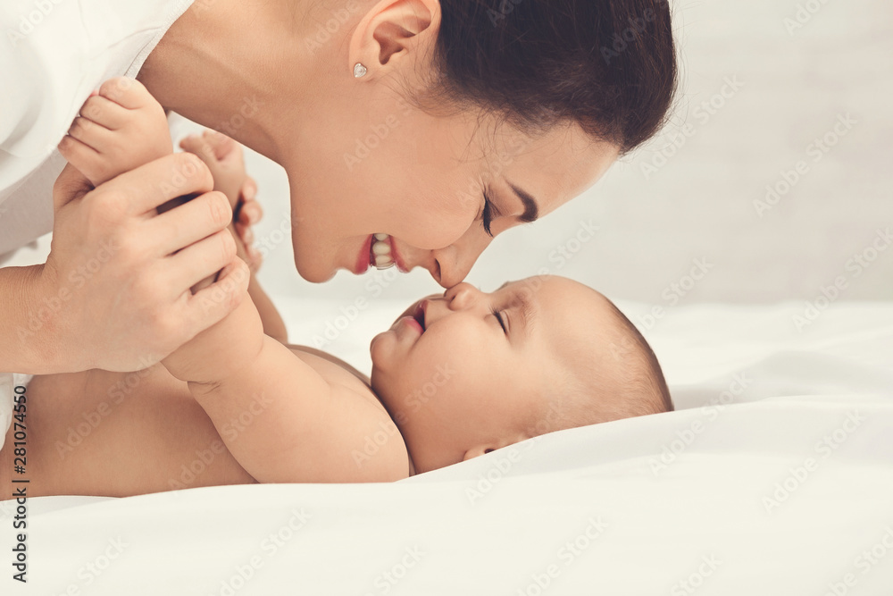 Mother and baby touching noses in bed Mother and baby touching noses in bed