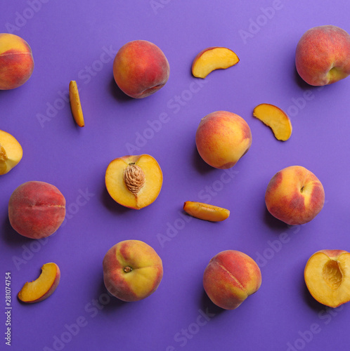 Flat lay composition with fresh peaches on purple background