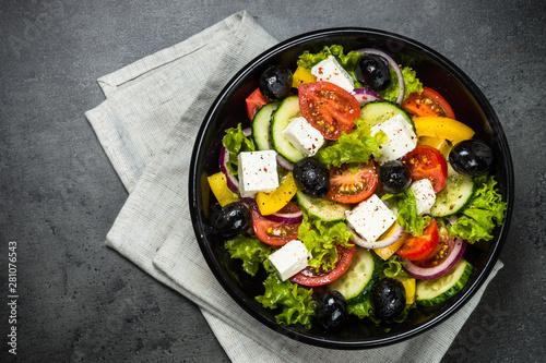 Greek salad in black plate on the table.
