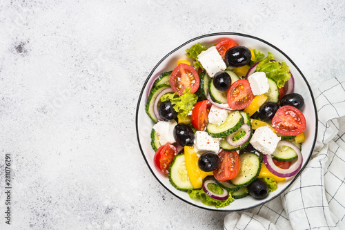 Greek salad in black plate on the table.