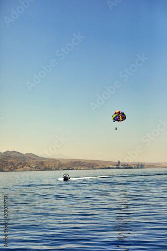 The view from the luxury yacht to the open red sea with the attraction flying on a parachute tied to a boat