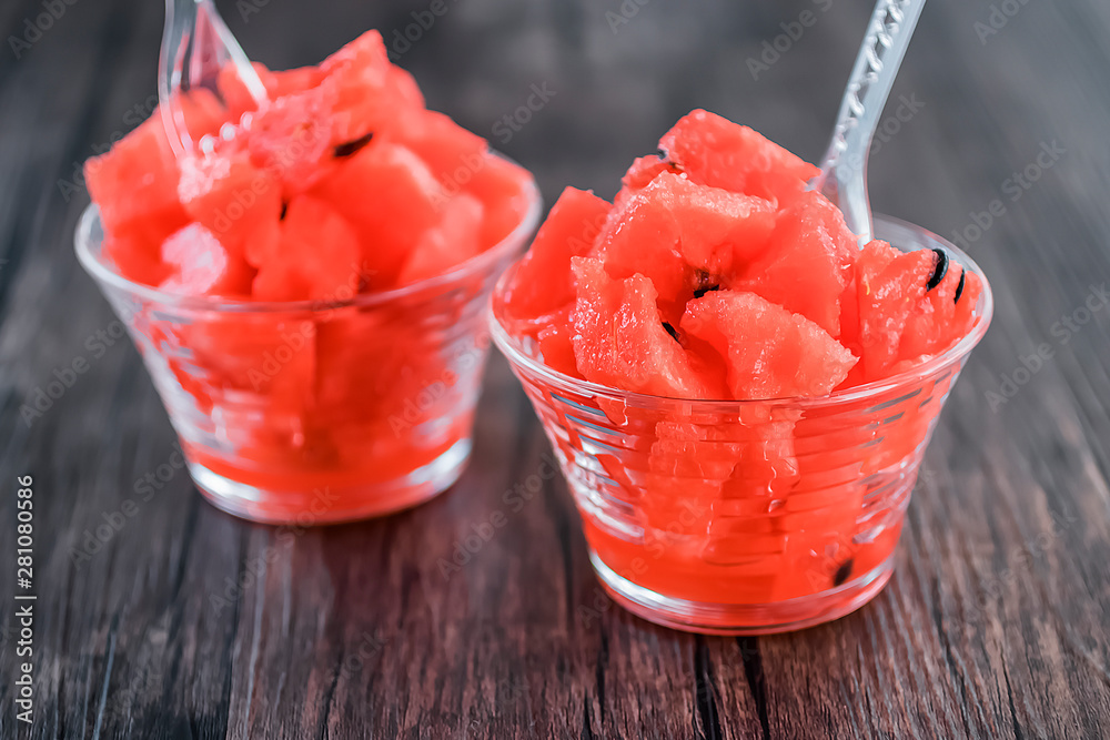 Dessert from sliced fresh watermelon in glass cups on a gray background. Dessert from sliced fresh watermelon in glass cups on a gray background.