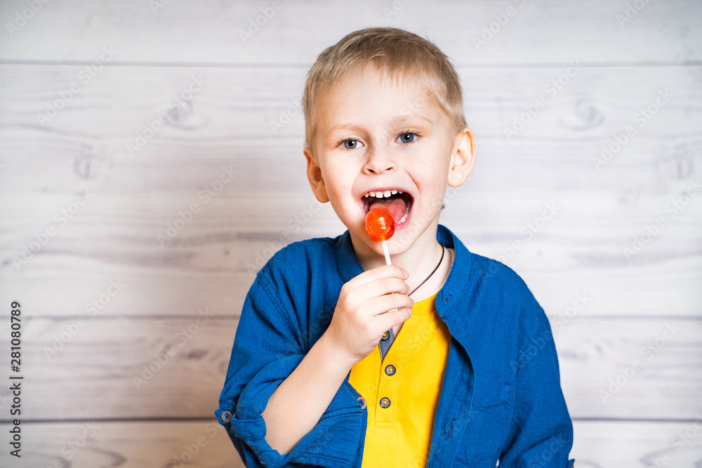 Cute little boy with lollipop. Happy boy eating candy Stock Photo