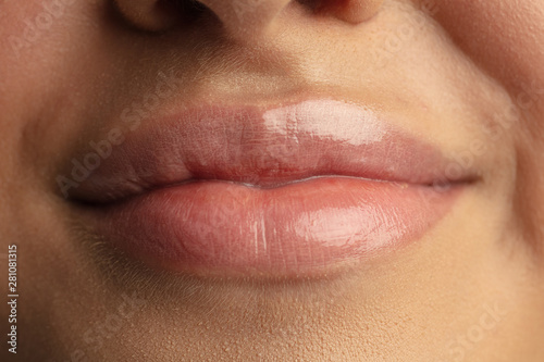 Close up photoshot of beautiful female lips. Highly detailed photo of model with perfect and well-kept skin. Concept of fashion, style, beauty, cosmetics, self-care. Human emotions, facial expression.