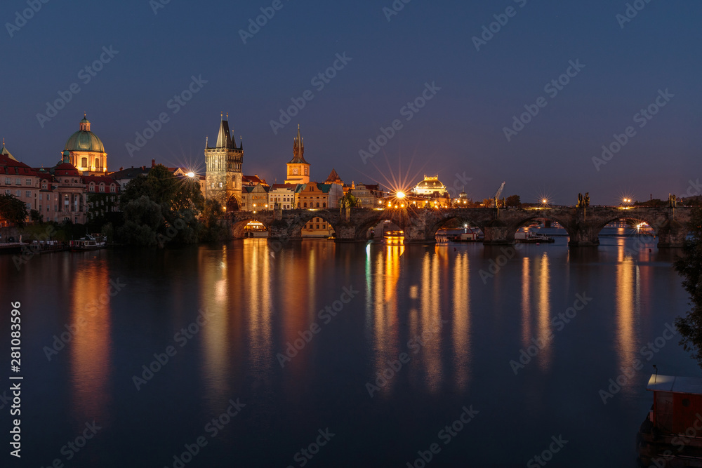 Pananorma view over the river Vltava. Old Town Prague at night with the historic stone bridge. Charles Bridge with illuminated Old Town tower and reflections in the water