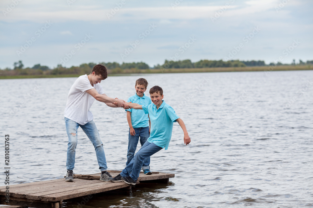 Group of happy cheerful beautiful children play near lake, outdoor Group of happy cheerful beautiful children play near lake, outdoor