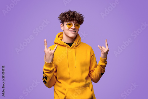 Foto Happy youngster showing rock gesture
