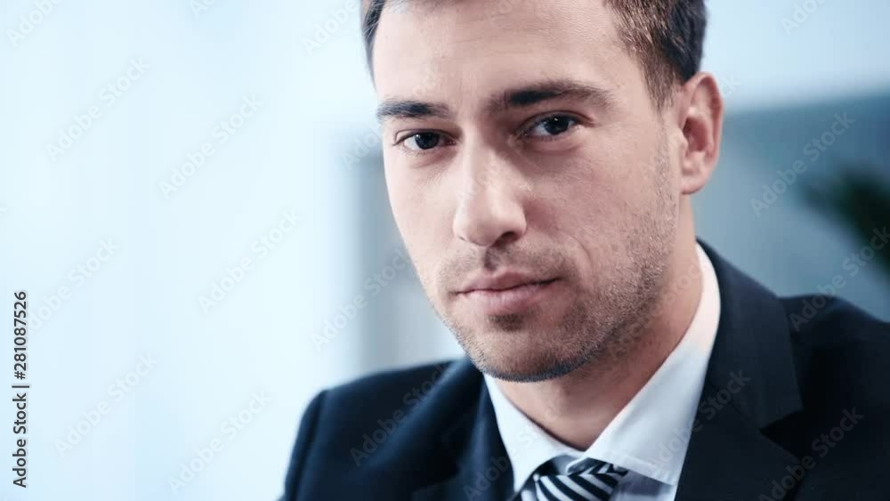 slow motion of positive, handsome businessman smiling while looking at camera slow motion of positive, handsome businessman smiling while looking at camera