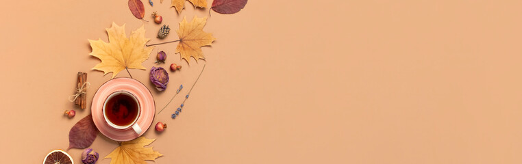 Autumn Flat lay composition. Cup of tea, autumn dry bright leaves, roses flowers, orange circle, cones, decorative pomegranate, cinnamon sticks on brown beige background top view. Autumn, fall concept