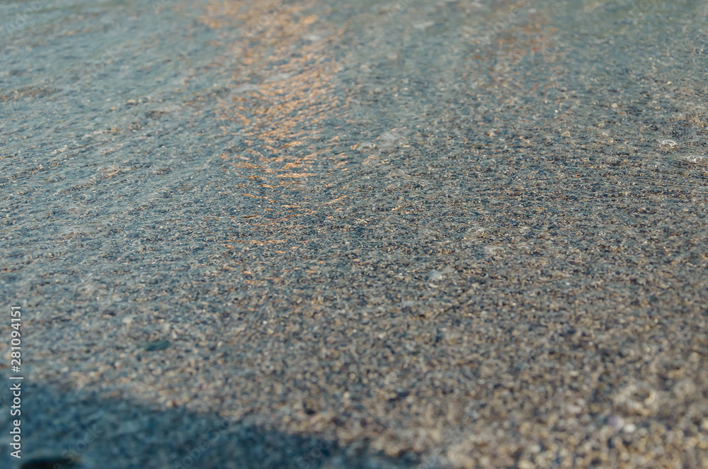 Closeup of sandy beach with soft incoming waves. Selective focus Closeup of sandy beach with soft incoming waves. Selective focus
