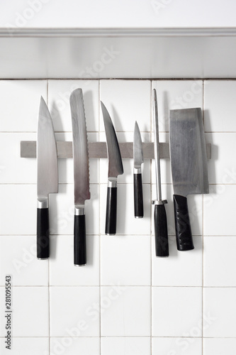 Set of knives on a magnitic bar on retro tiled wall
