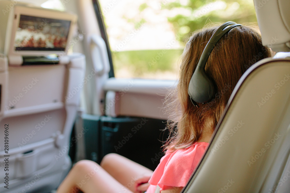 Cute young girl watching entertainment in a car