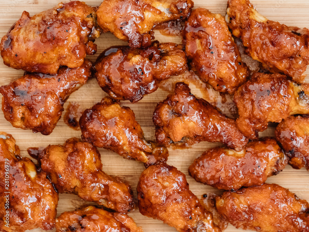 Crispy barbecue chicken wings covered in a sweet and tangy bbq sauce and served at a cookout. Crispy barbecue chicken wings covered in a sweet and tangy bbq sauce and served at a cookout.