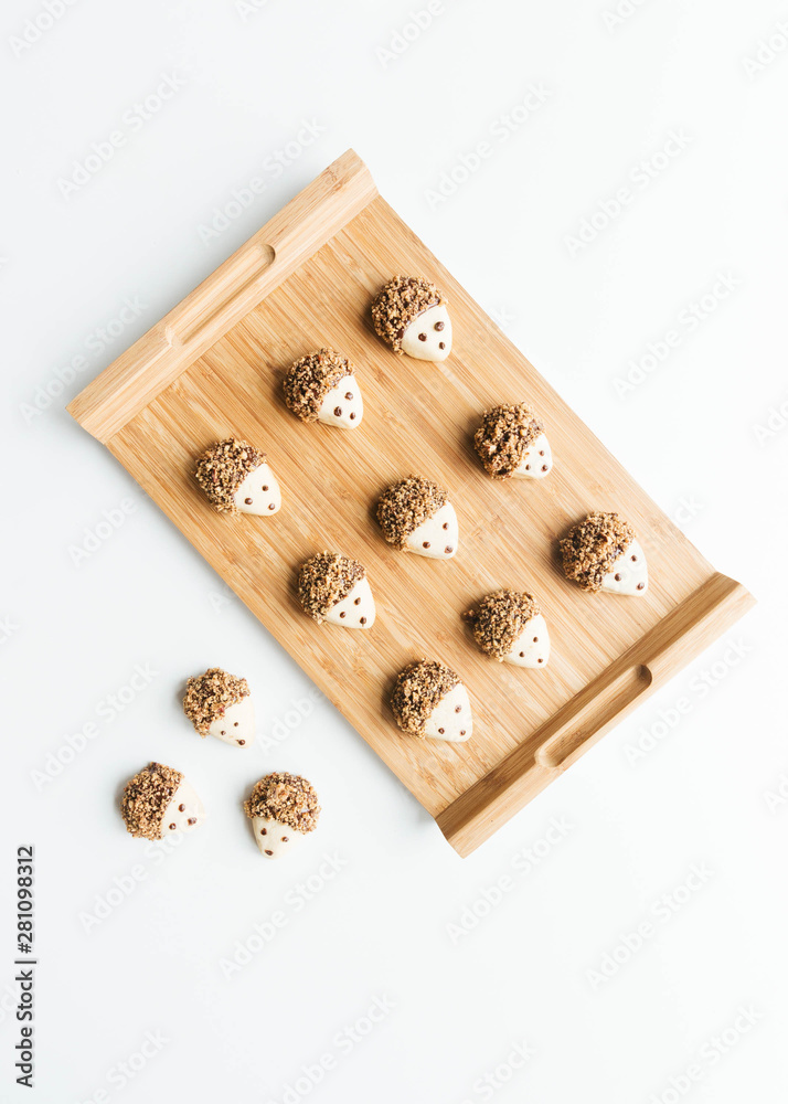 Pecan and dark chocolate covered hedgehog cookies on wooden tray Pecan and dark chocolate covered hedgehog cookies on wooden tray
