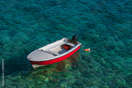 Boat on the waves near the shore. Clear blue water of the Adriatic sea.