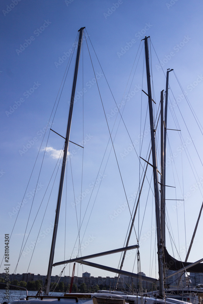 High masts of yachts against a blue sky