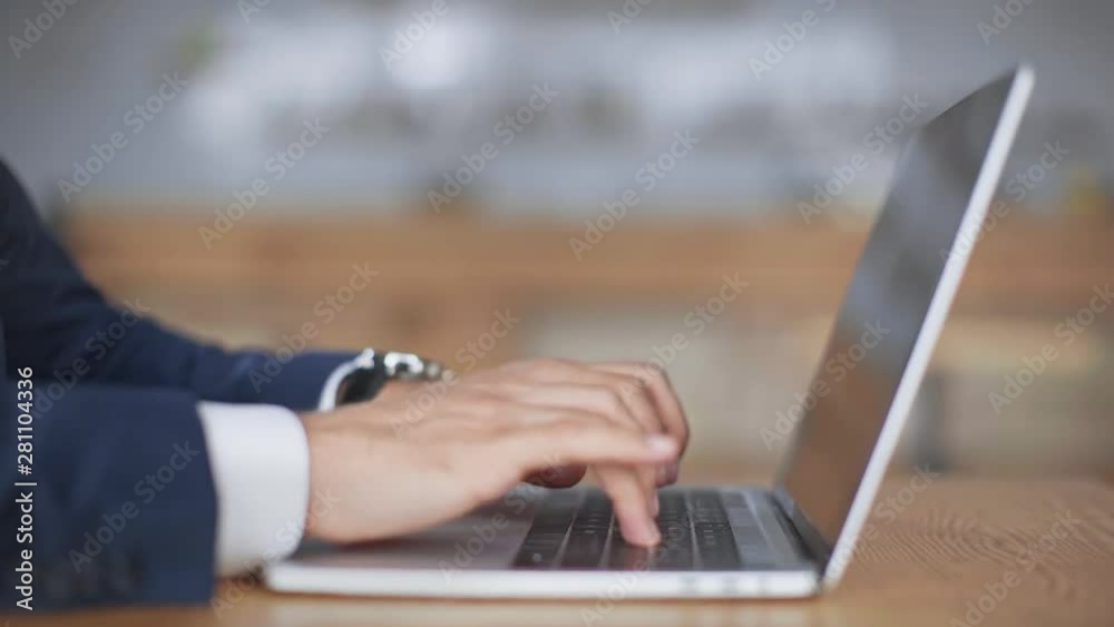 cropped view of businessman in formal wear using laptop while sitting in cafe cropped view of businessman in formal wear using laptop while sitting in cafe