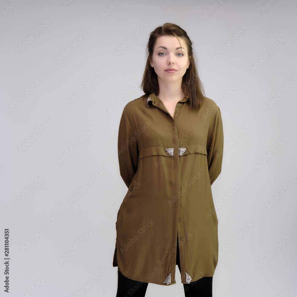 A portrait above the knee of a pretty adult brunette girl in a dress on a white background. Standing directly in front of the camera, showing different poses and emotions. A portrait above the knee of a pretty adult brunette girl in a dress on a white background. Standing directly in front of the camera, showing different poses and emotions.