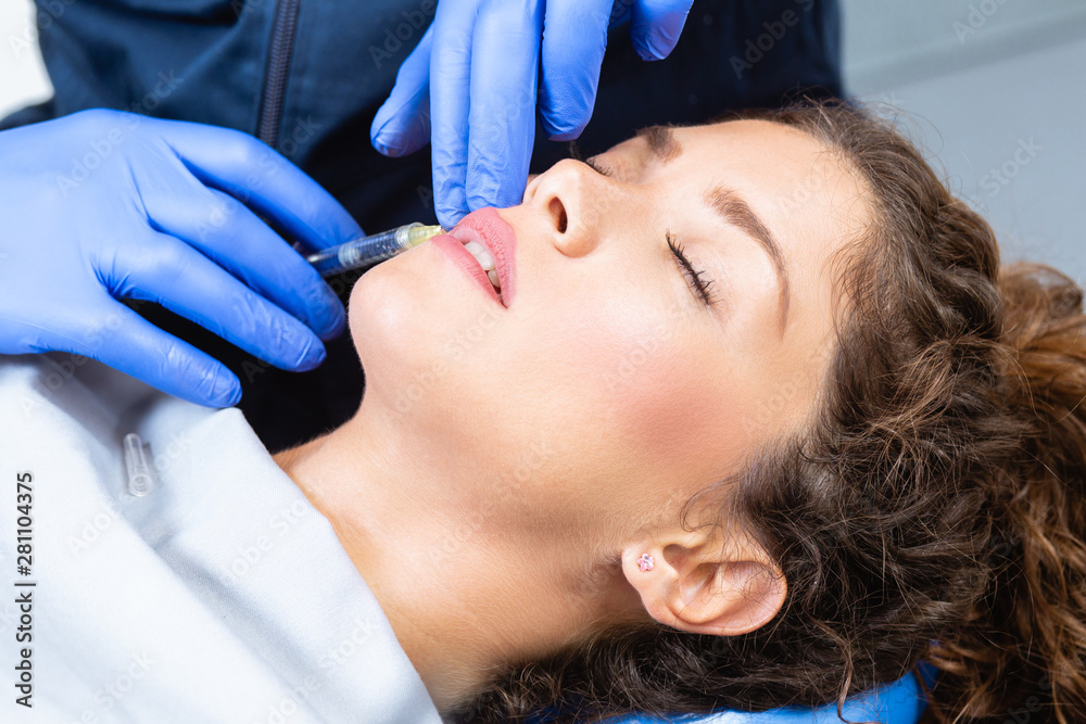 Naklejka premium Medical procedure on woman's lips with hyaluronic acid.