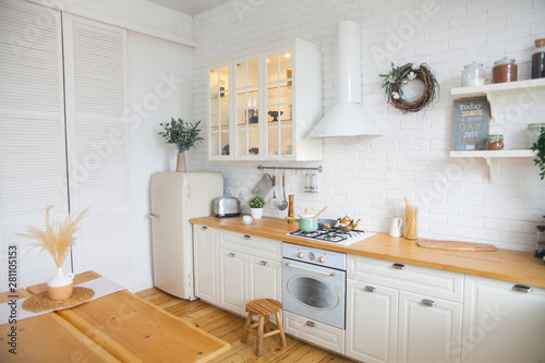 Fototapeta Naklejka Na Ścianę i Meble -  Interior of modern sunny kitchen in a Scandinavian-style apartment. Kitchen furniture, dishes, spices