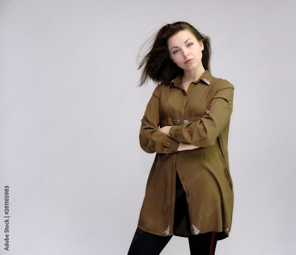 A portrait above the knee of a pretty adult brunette girl in a dress on a white background. Standing directly in front of the camera, showing different poses and emotions. A portrait above the knee of a pretty adult brunette girl in a dress on a white background. Standing directly in front of the camera, showing different poses and emotions.