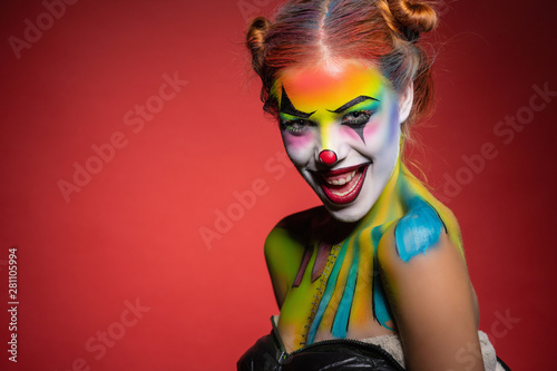 Beautiful young lady with a face painting clown.