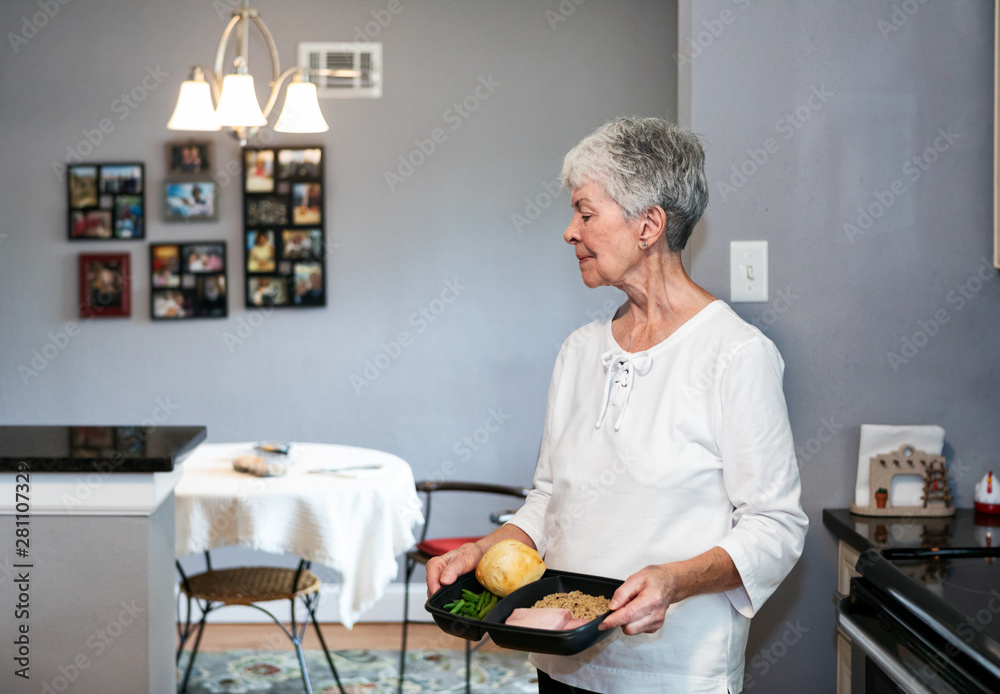 Meal: Woman Carries Heated Delivered Meal To Table Meal: Woman Carries Heated Delivered Meal To Table