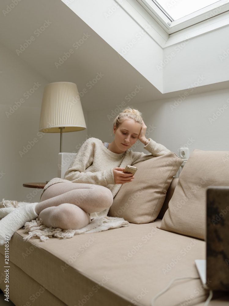 Woman on cozy sofa using phone Woman on cozy sofa using phone