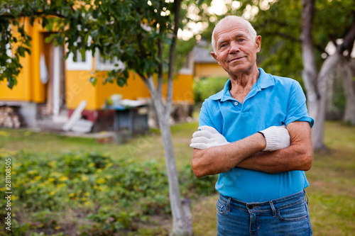 Fototapeta Naklejka Na Ścianę i Meble -  Portrait of positive mature farmer in his garden