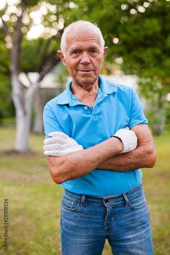Elderly gardener posing in his garden